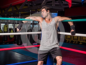 Young male boxer resting against boxe ring ropes photo