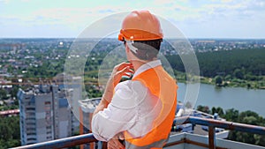 Young male builder standing on the roof of construction site while thinking about new project. Business, building