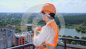 Young male builder standing on the roof of construction site while thinking about new project. Business, building