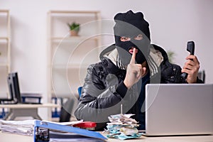 Young male burglar in the office