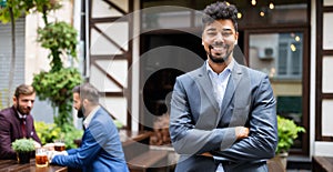 Young male business owner standing near his new local. Startup, entrepreneur, business concept.