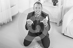 Young male businessman anger, hysterical kneeling on the floor, screaming and holding crumpled paper in his hands.