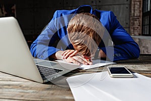 Young male businessman in blue suit, upset, tired and in depress