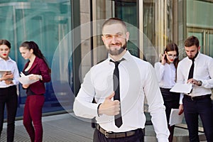 A young male businessman is enjoying a successful deal on the ba photo