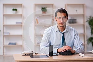 Young male call center operator working at his desk
