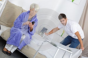 Young male carer spending time with elderly woman