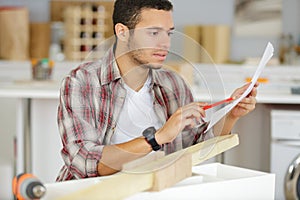 young male carpenter reading instructions