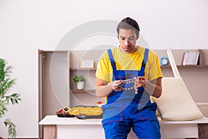 Young male carpenter stealing jewelry at home