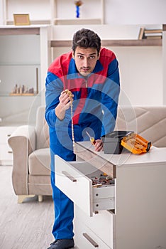 Young male carpenter stealing jewelry at home