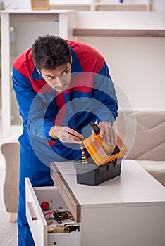 Young male carpenter stealing jewelry at home