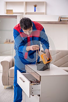 Young male carpenter stealing jewelry at home