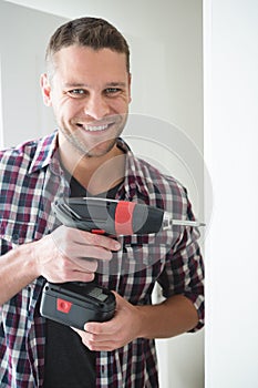 Male carpenter using drill machine