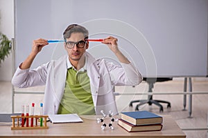 Young male chemist in the classroom