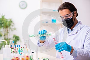 Young male chemist in drug synthesis concept