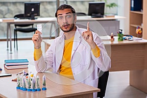 Young male chemist in drug synthesis concept