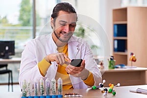 Young male chemist in drug synthesis concept