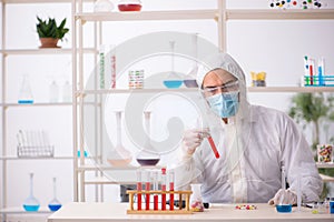 Young male chemist in drugs syntesis concept