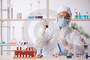 Young male chemist in drugs syntesis concept