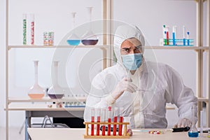 Young male chemist in drugs syntesis concept