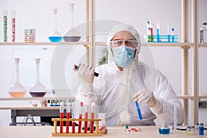 Young male chemist in drugs syntesis concept