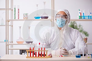 Young male chemist in drugs syntesis concept