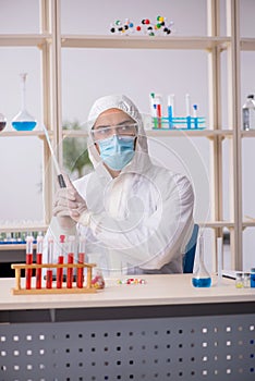 Young male chemist in drugs syntesis concept