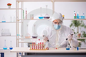 Young male chemist in drugs syntesis concept