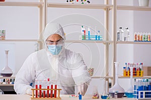 Young male chemist in drugs syntesis concept