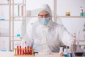 Young male chemist in drugs syntesis concept