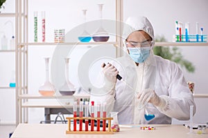 Young male chemist in drugs syntesis concept photo