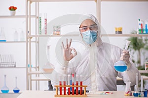 Young male chemist in drugs syntesis concept photo