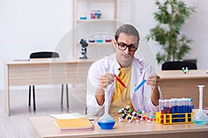 Young male chemist teacher in the classroom
