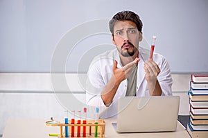 Young male chemist teacher in front of whiteboard