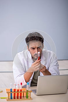 Young male chemist teacher in front of whiteboard