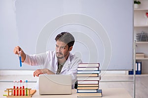 Young male chemist teacher in front of whiteboard