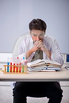 Young male chemist teacher in front of whiteboard