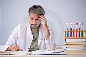 Young male chemist teacher in front of whiteboard