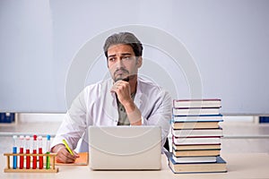 Young male chemist teacher in front of whiteboard