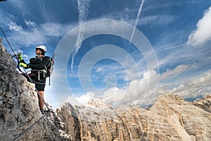 Young male climber on an exposed Via Ferrata in the Dolomites