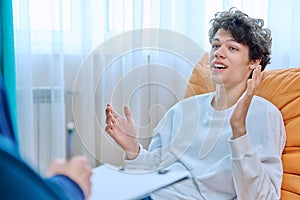 Young male college student in therapy session with psychologist