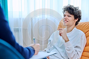 Young male college student in therapy session with psychologist