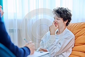 Young male college student in therapy session with psychologist