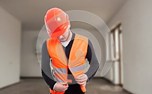 Young male constructor adjusting his protection vest