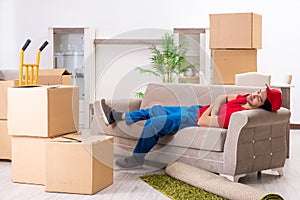 Young male contractor with boxes working indoors