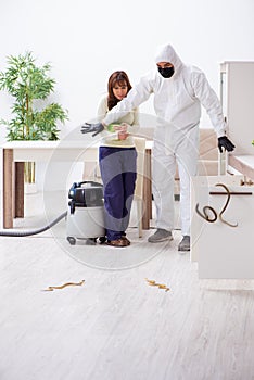 Young male contractor exterminating snakes in the flat