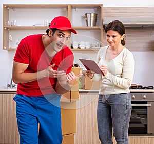 Young male contractor and female customer in moving concept