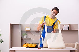 Young male contractor repairing chair at home