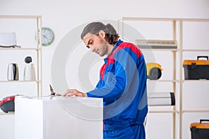 Mladý samec dodávateľ oprava chladnička na dielňa 