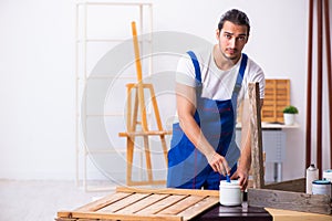 Young male contractor working in workshop