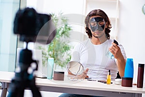Young male cosmetician recording video for his blog